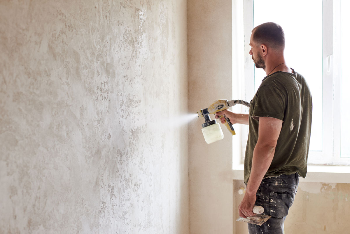 Man spraying wall paint