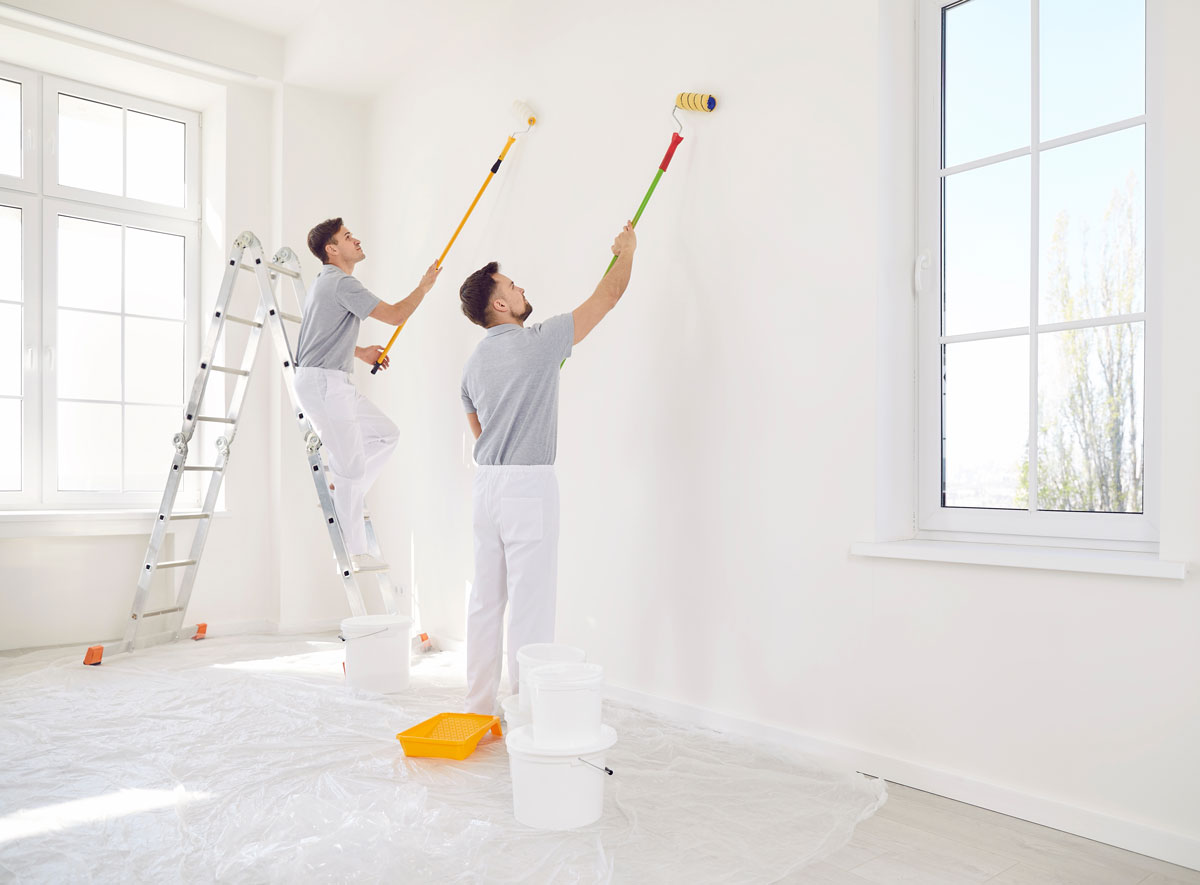 Two men painting a wall